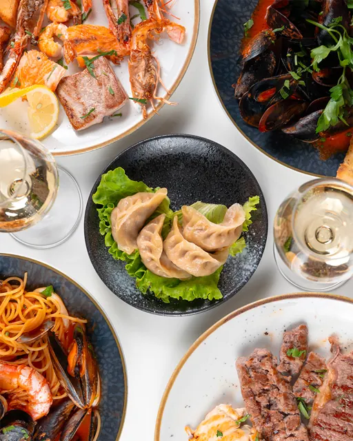 Ravioli, gamberi, cozze e tagliata sulla stessa tavola